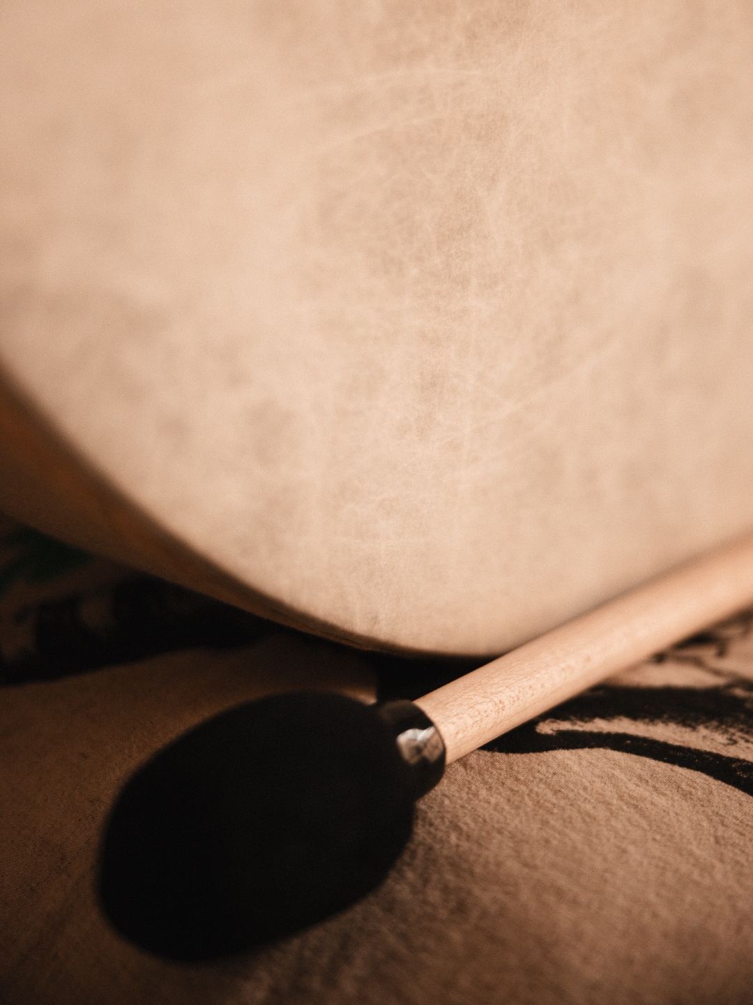 Bronze gong mounted on a wood-slat wall beside singing bowls and mallets